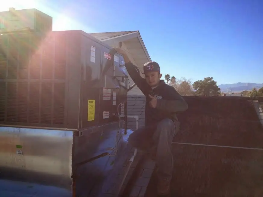 HVAC technician performing AC Tune-Up on a rooftop unit in Gentry